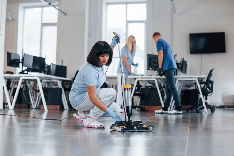 woman-uses-vacuum-cleaner-group-of-workers